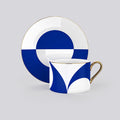 Blue and white geometric patterned teacup and saucer set with gold trim, shown on a light gray background.